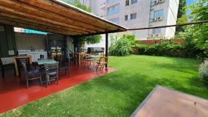 a patio with tables and chairs in a yard at Hotel JBJ in Mendoza