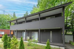 a house with a black exterior at DogrunCafe & Resorts JENNIE West-Karuizawa in Miyota