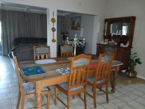 a dining room with a wooden table and chairs at Healboys Self - catering Accommodation in Bonnievale