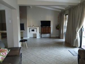 a living room with a couch and a tv on a wall at Healboys Self - catering Accommodation in Bonnievale +44 photos
