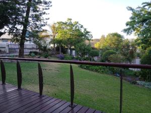 a wooden deck with a fence and a garden at Healboys Self - catering Accommodation in Bonnievale