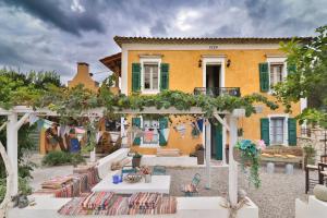 a house with an outdoor patio with tables and chairs at Villa Ochre - Rustic Retreat in Tsilivi