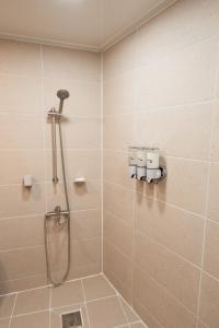 a bathroom with a shower with a shower head at Stay SUM in Kwarye +18 photos