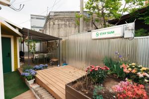 a garden with flowers and a sign that reads s star sun at Stay SUM in Kwarye