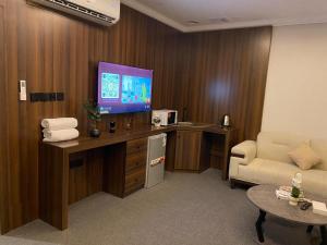a hotel room with a television and a couch at شقق اضواء رفا للشقق المخدومة 4 in Al Kharj +8 photos