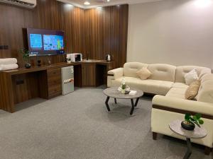 a living room with a couch and a tv at شقق اضواء رفا للشقق المخدومة 4 in Al Kharj