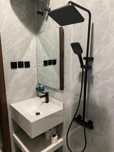a bathroom with a white sink and a shower at شقق اضواء رفا للشقق المخدومة 4 in Al Kharj
