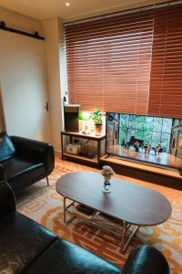 a living room with a coffee table and a large window at Stay SUM in Kwarye