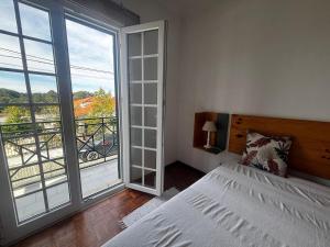 a bedroom with a bed and a large window at Casa do Meco - Private Pool in Sesimbra