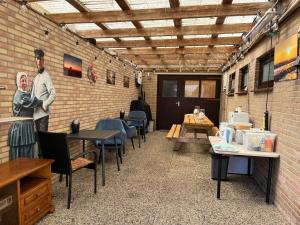 a restaurant with tables and a man standing in a brick wall at B&B Nobel in Buren