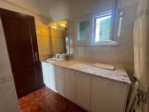 a white bathroom with a sink and a mirror at Casa do Meco - Private Pool in Sesimbra +28 photos