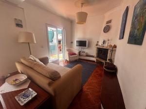 a living room with a couch and a fireplace at Casa do Meco - Private Pool in Sesimbra