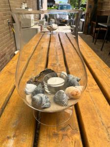 a glass bowl filled with shells on a wooden table at B&B Nobel in Buren