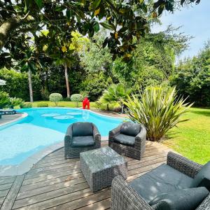 a pool with two chairs and a table in front of it at Villa Sunlight Mougins in Mougins