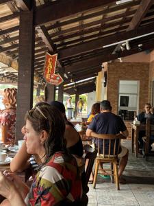 a group of people sitting at a table in a restaurant at casa tres quartos condominio aeroporto lazer praias mercados a poucos minutos in Salvador