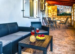 a patio with a table with two glasses of wine at Casa Di Aspa-Serene Escape with Pool near town in Rethymno