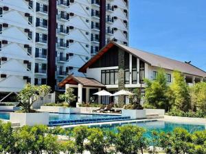 a building with a swimming pool in front of a building at City View Studio Pool - Gym - Caesar Residence in Mactan Island