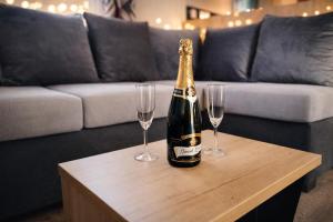 a bottle of champagne on a table with two wine glasses at Chez Achille in Marcilly-sur-Eure