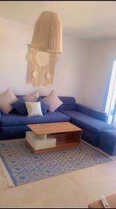 a living room with a blue couch and a coffee table at MV Ras El Hakma 190 A in Ras Elhekma