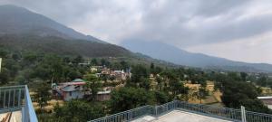 a view of a mountain from the balcony of a house at Touch wood guest house in Dharmsāla