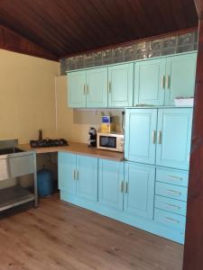 a kitchen with white cabinets and a microwave at Cocon de Grand Anse in Petite Île +12 photos