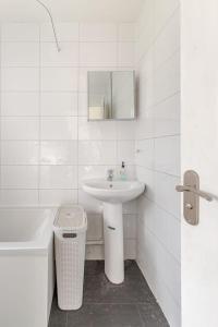 a white bathroom with a sink and a mirror at Spacious Riverside View Bungalow in Oxford +17 photos