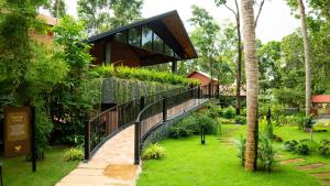 a modern house with a walkway in a garden at Athirapilly Fernvalley Resort in Athirappilly