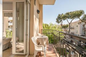 a balcony with a table and chairs on a balcony at Hotel Arlecchino Riccione in Riccione