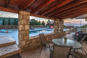 a patio with a table and chairs and a pool at Casa Di Aspa-Serene Escape with Pool near town in Rethymno