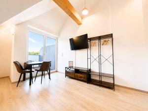 a dining room with a table and chairs and a television at Ort 245 in Ried im Innkreis