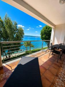 a balcony with a table and a view of the ocean at App LOLLY in Selce