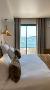 a bedroom with a bed with a view of the ocean at Hotel Restaurant Les Venetes in Arradon