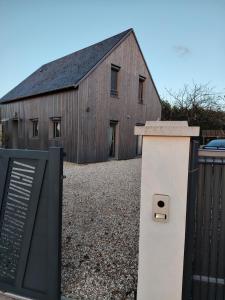 a wooden barn with a gate and a fence at Chambre récente chez particuliers in Francueil