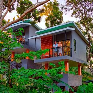 two people standing on the balcony of a house at Buxton Gan Resort Hotel in San Andres