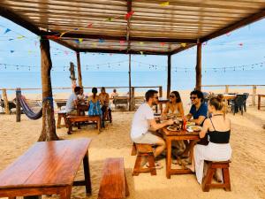 a group of people sitting at a table on the beach at Arugam Bay Resort in Arugam Bay