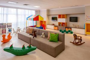 a living room with a couch and some toys in it at Bourbon Convention Hotel Santos in Santos