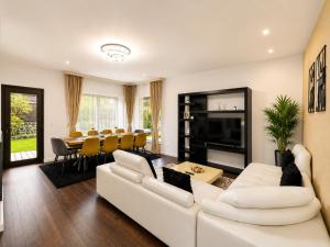 a living room with a white couch and a table at Vila Panorama - Bunloc in Săcele