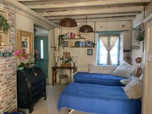 a living room with two blue beds and a window at Villa Ochre - Rustic Retreat in Tsilivi