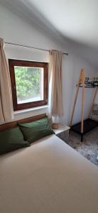 a bedroom with a bed with a window and a ladder at Jamm Mare e Monti Tiny house in Orebić