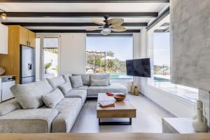 a living room with a couch and a ceiling fan at Villa Aegea in Skopelos Town
