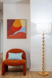 a room with a chair and a lamp at Park side on East Terrace in Adelaide