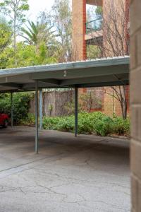 a parking lot with awning in front of a building at Park side on East Terrace in Adelaide +14 photos