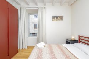 a white bedroom with a bed and a window at CityLife in Bergamo