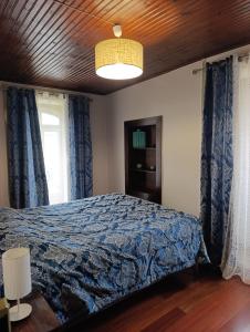 a bedroom with a bed with a blue comforter at Casa do Pelourinho in Coja