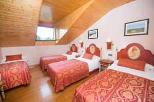 a hotel room with three beds and a window at Hospederia La Cañada in Moralzarzal +20 photos