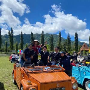 a group of people sitting on the back of an orange truck at Homestay Durohman Borobudur in Mendut