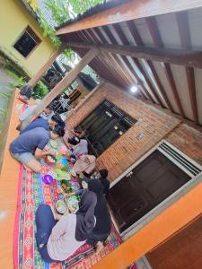 a group of people sitting at a table eating food at Homestay Durohman Borobudur in Mendut +12 photos