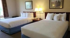 a hotel room with two beds and a telephone at Magnason Hotel in West Liberty