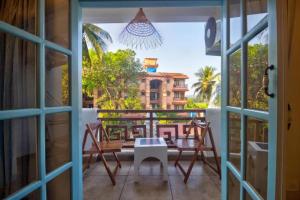 a balcony with a table and chairs and a view of a building at Casa Pajaros in Calangute