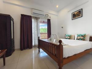 a bedroom with a large bed and a window at RVS Chalet in Pondicherry